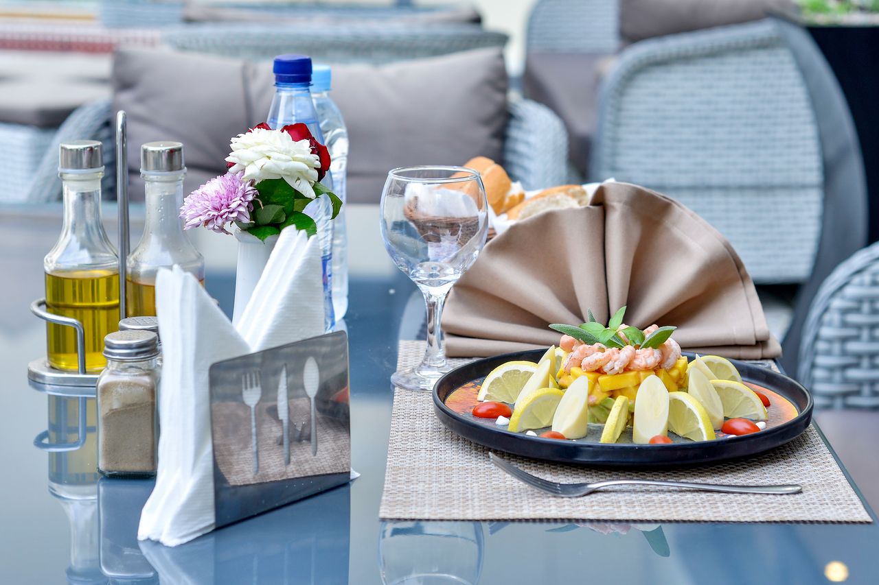 services-03 A delectable shrimp dish with lemon slices elegantly set on a restaurant table, showcasing a sophisticated dining experience.
